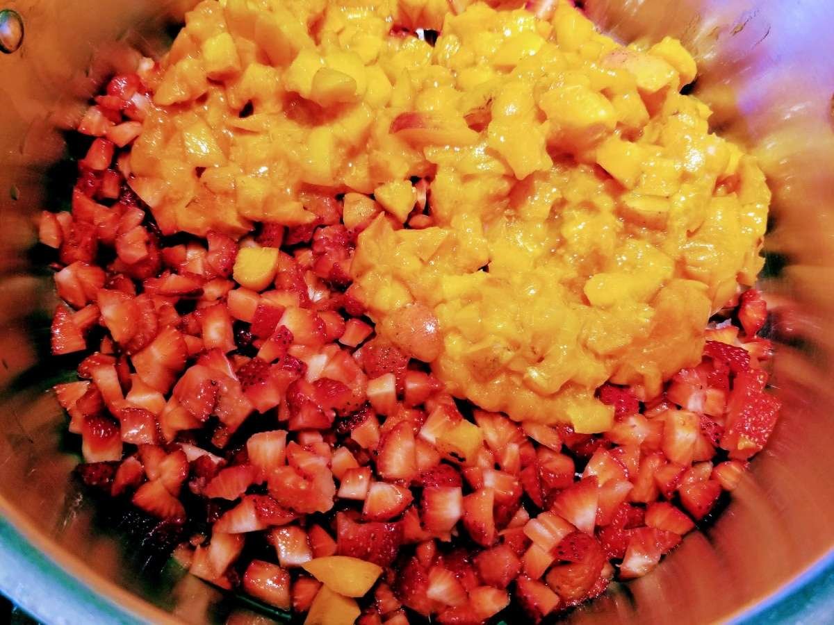 chopped apricots and strawberries in pot for jam