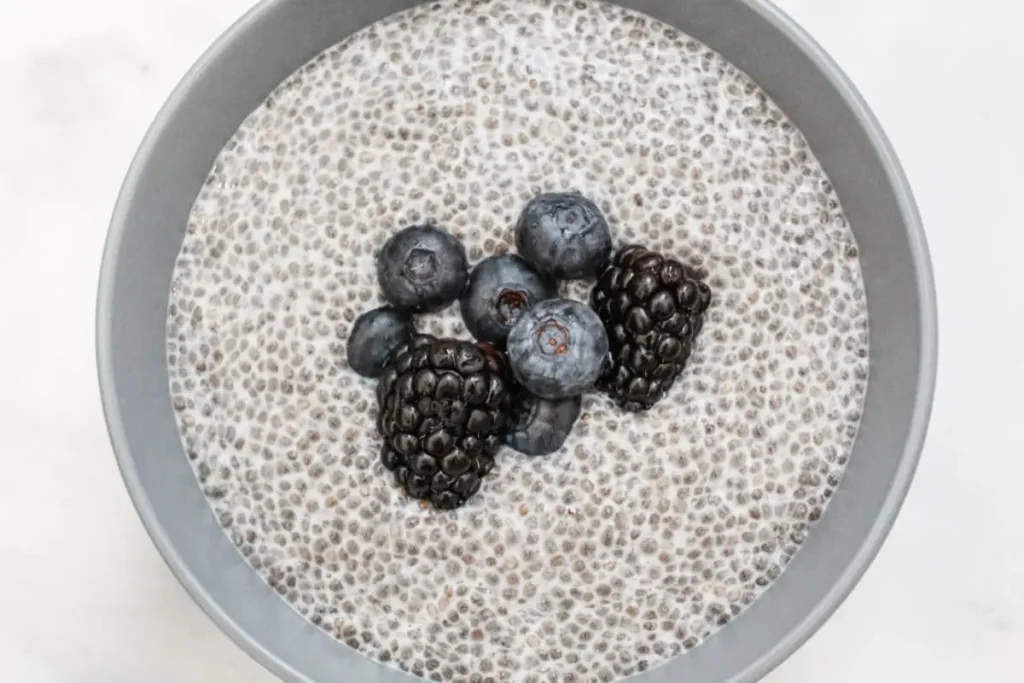 non dairy chia seed pudding with berries on top and in a blue bowl