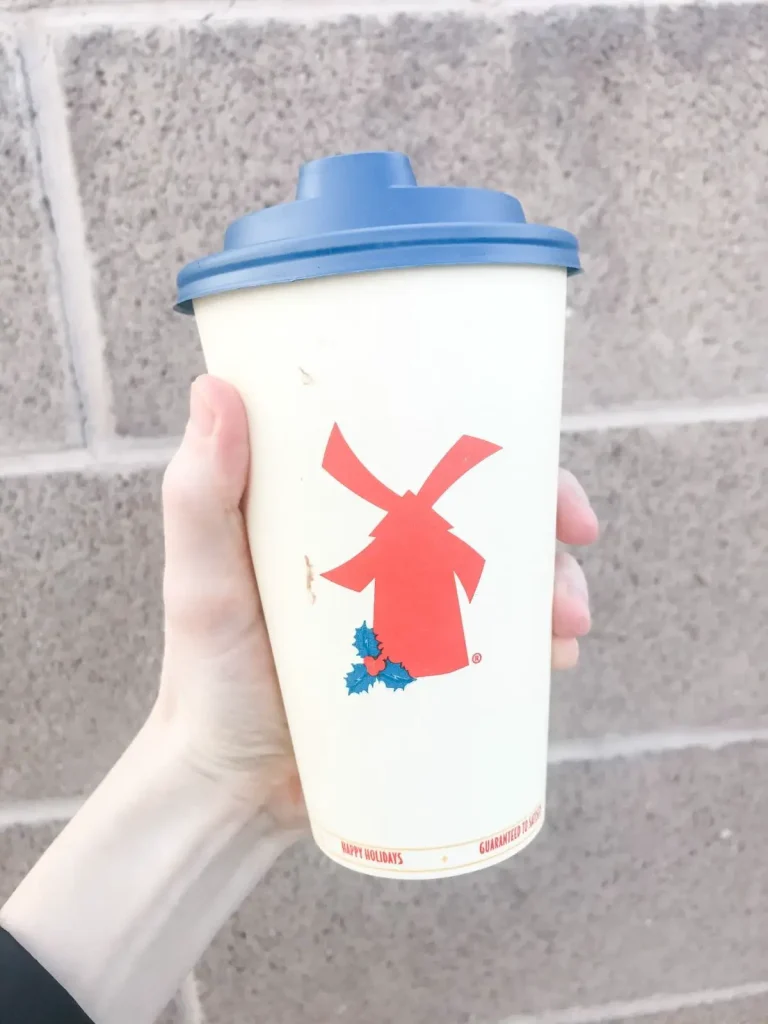 dutch bros vegan hot mocha with oat milk, chocolate, and salted caramel against a brick background