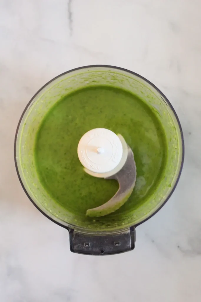 all of the pesto ingredients all blended up in the food processor