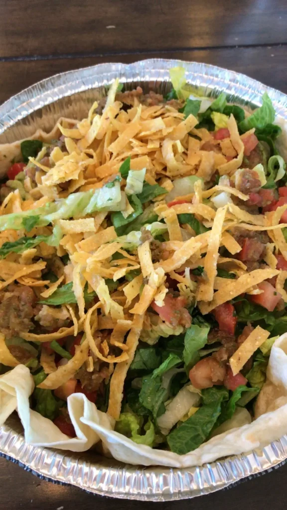 veggie salad from costa vida in a foil tin with lettuce, pico de gallo, chip strips, and salsa