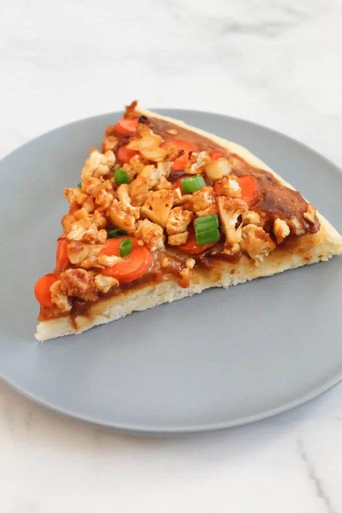 slice of finished thai pizza topped with green onions on blue plate