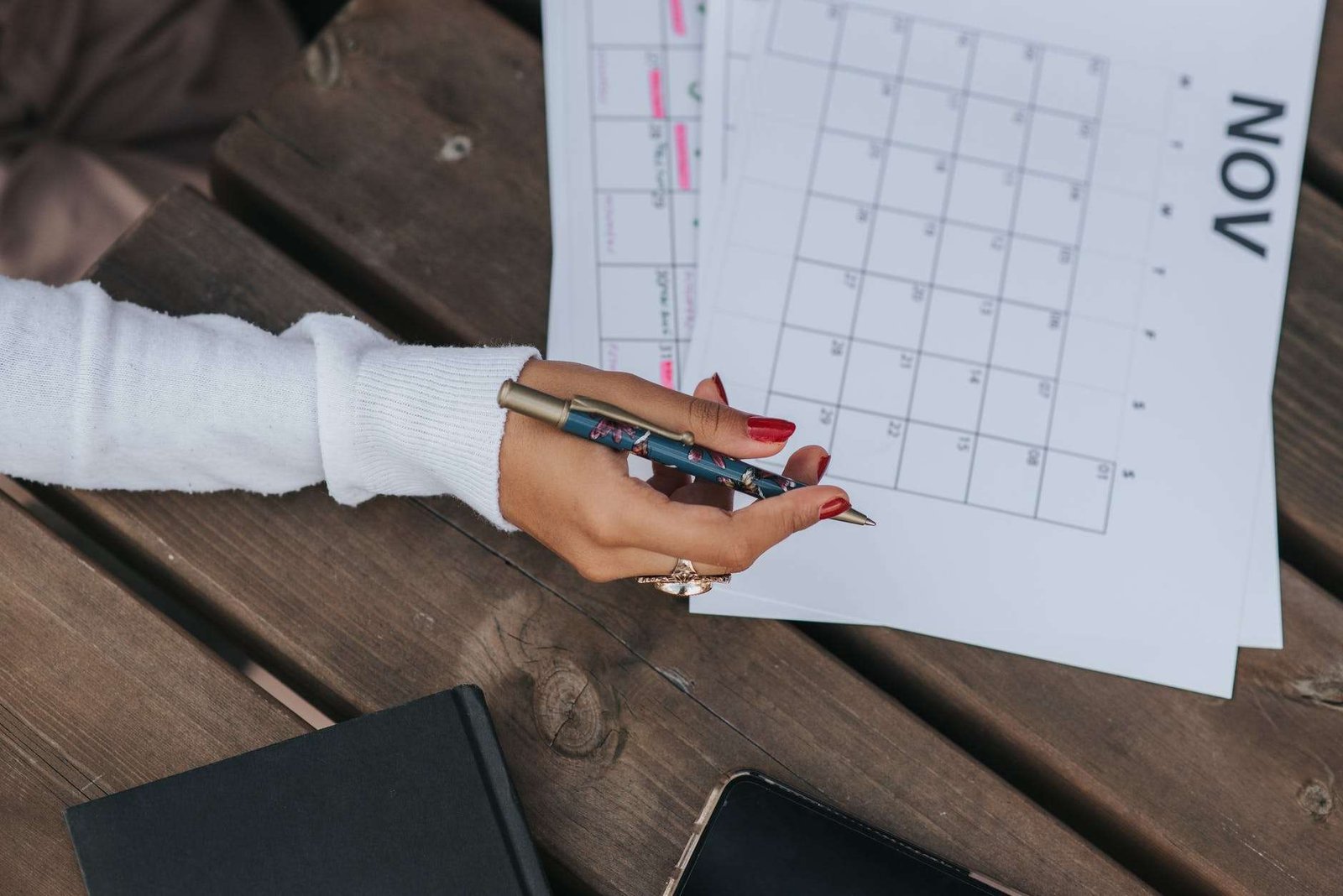 crop woman writing in calendar