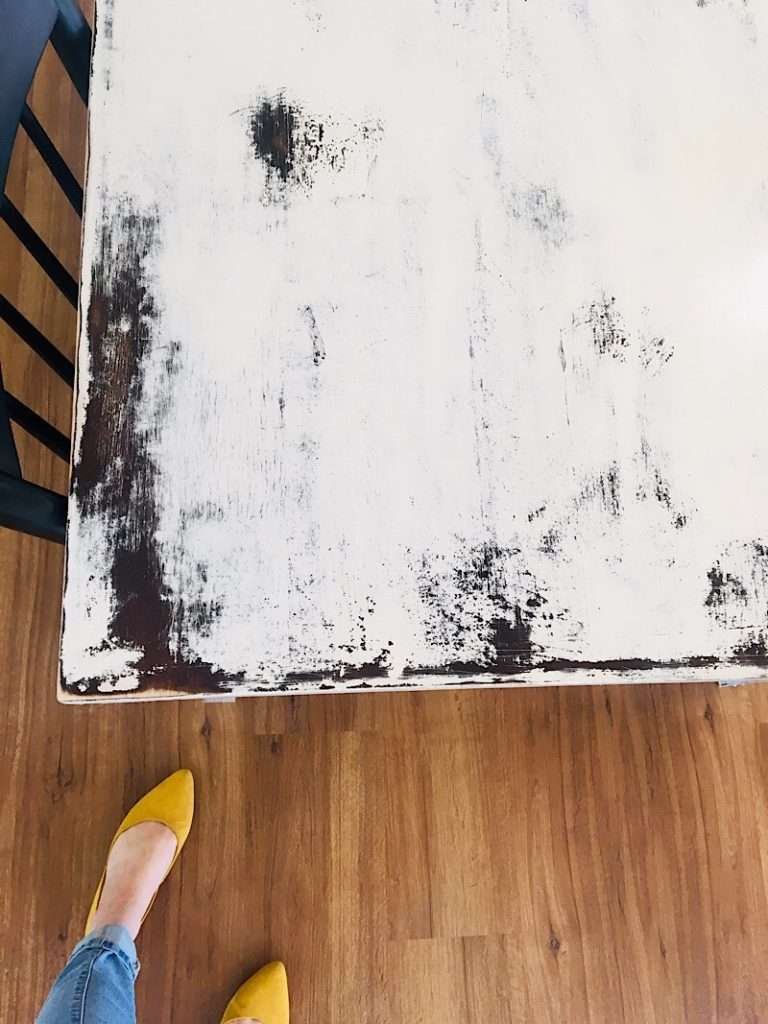 white farmhouse table with shoes and feet