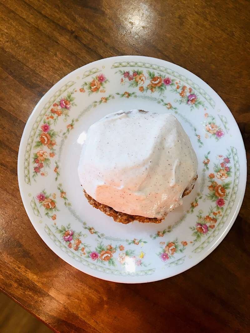 applesauce muffin on a plate with cream cheese frosting