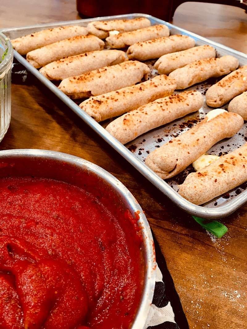 Pizza sticks on pan with marinara sauce