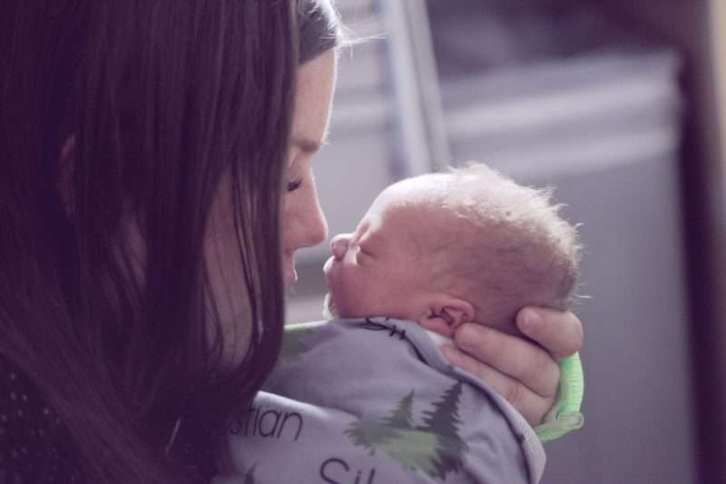 woman kissing her healthy baby